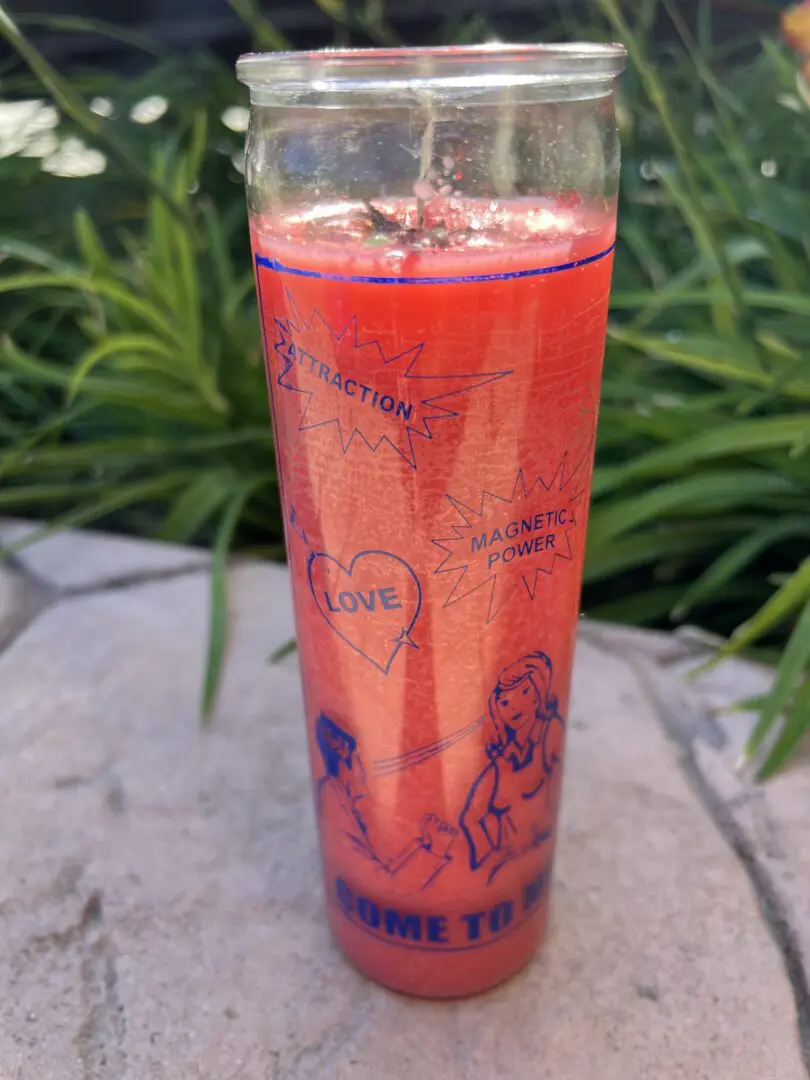 A candle that is sitting on the ground. A candle that is sitting on the ground.