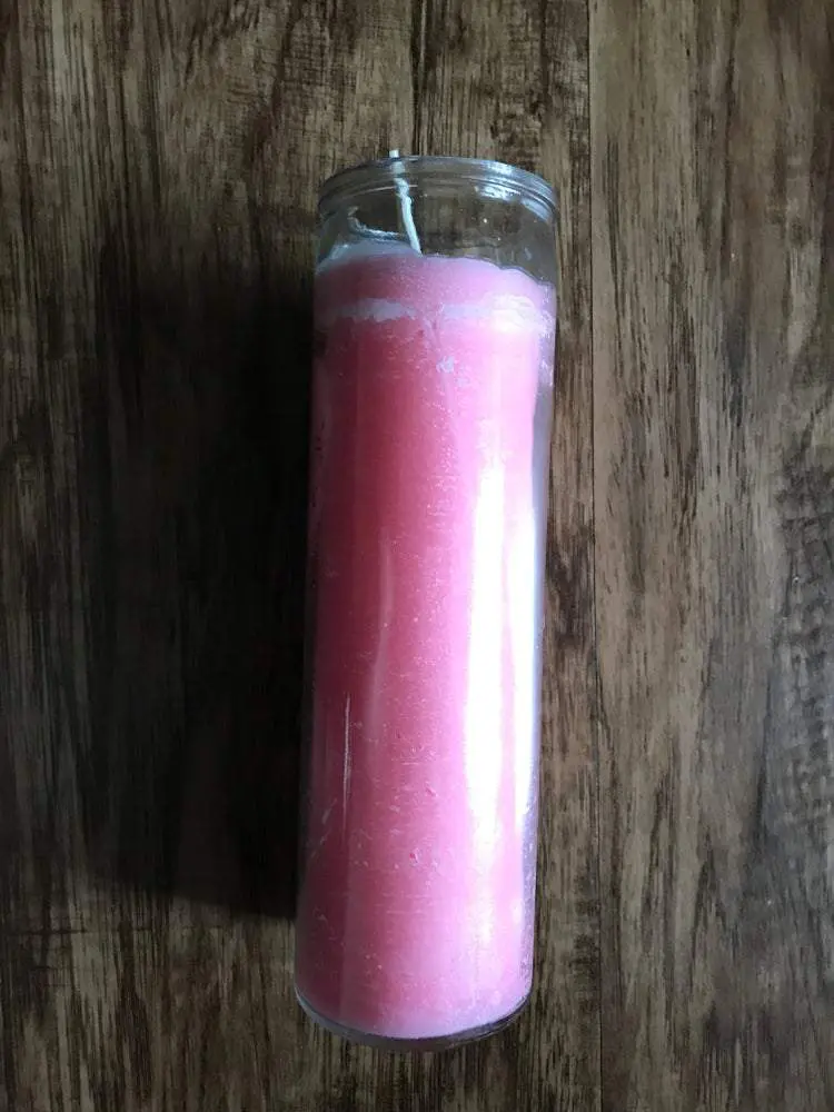 Pink glass jar candle on wood table. Pink glass jar candle on wood table.