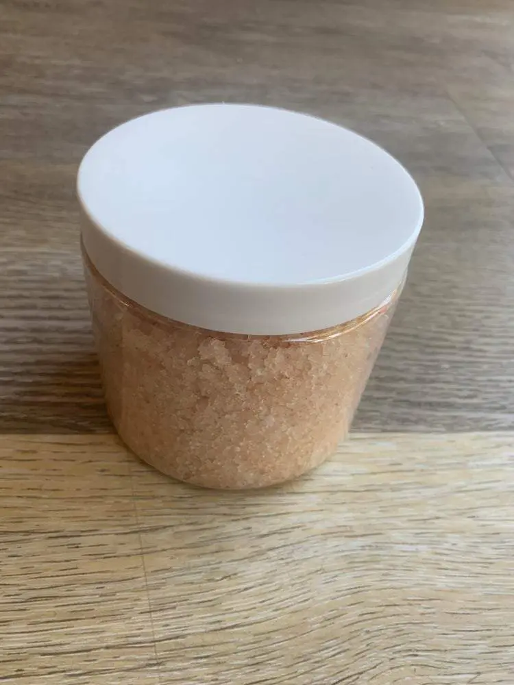 Jar of pink bath salts on wood table. Jar of pink bath salts on wood table.