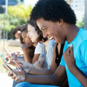 Man excited looking at phone with friends.