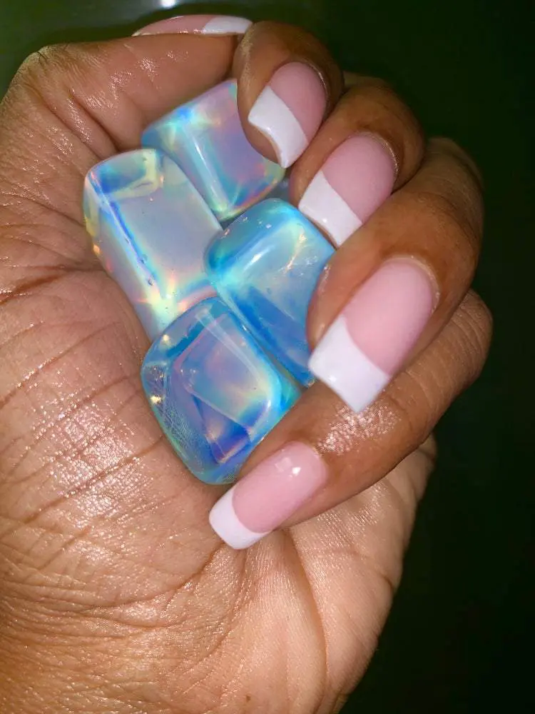 Hand holding iridescent blue and white crystals. Hand holding iridescent blue and white crystals.