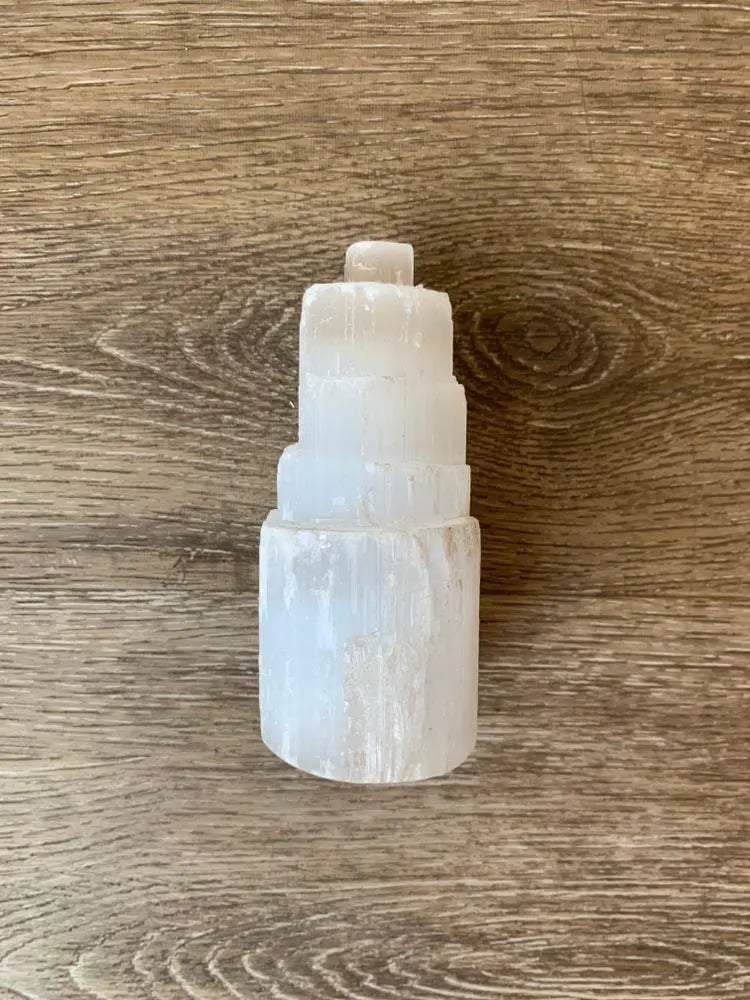 White selenite crystal tower on wood White selenite crystal tower on wood