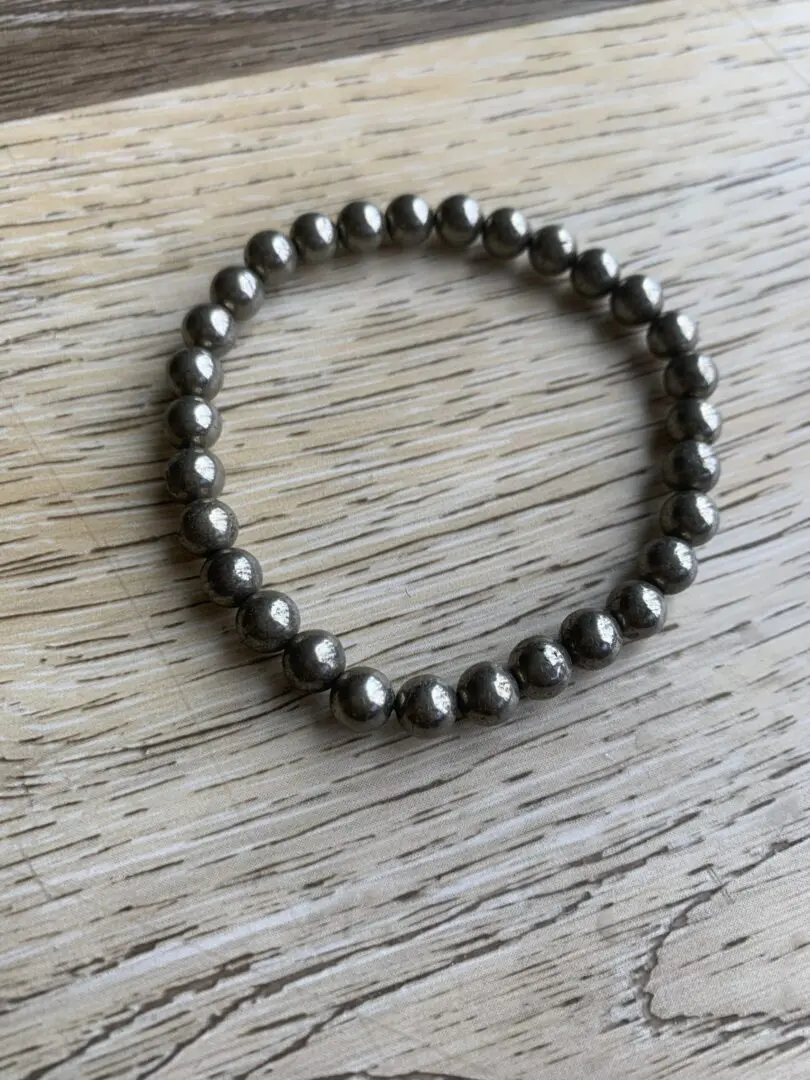 Pyrite stone beaded bracelet on wood. Pyrite stone beaded bracelet on wood.