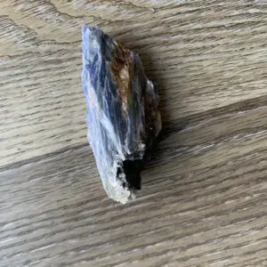 Blue and brown rock on wood grain.