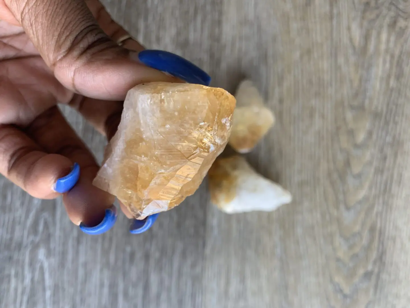 Hand holding a yellow citrine crystal. Hand holding a yellow citrine crystal.