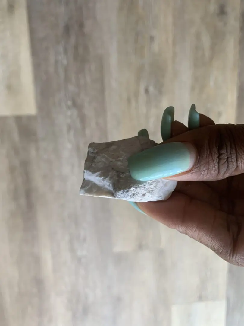 Hand holding a white, rough stone. Hand holding a white, rough stone.