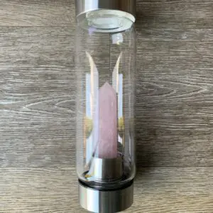 Rose quartz crystal in a glass water bottle.