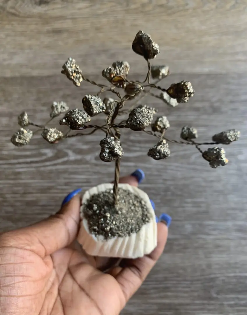 Pyrite crystal tree in hand, white base. Pyrite crystal tree in hand, white base.