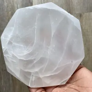 White selenite crystal plate in hand.