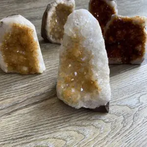 Four citrine crystal clusters on wood.