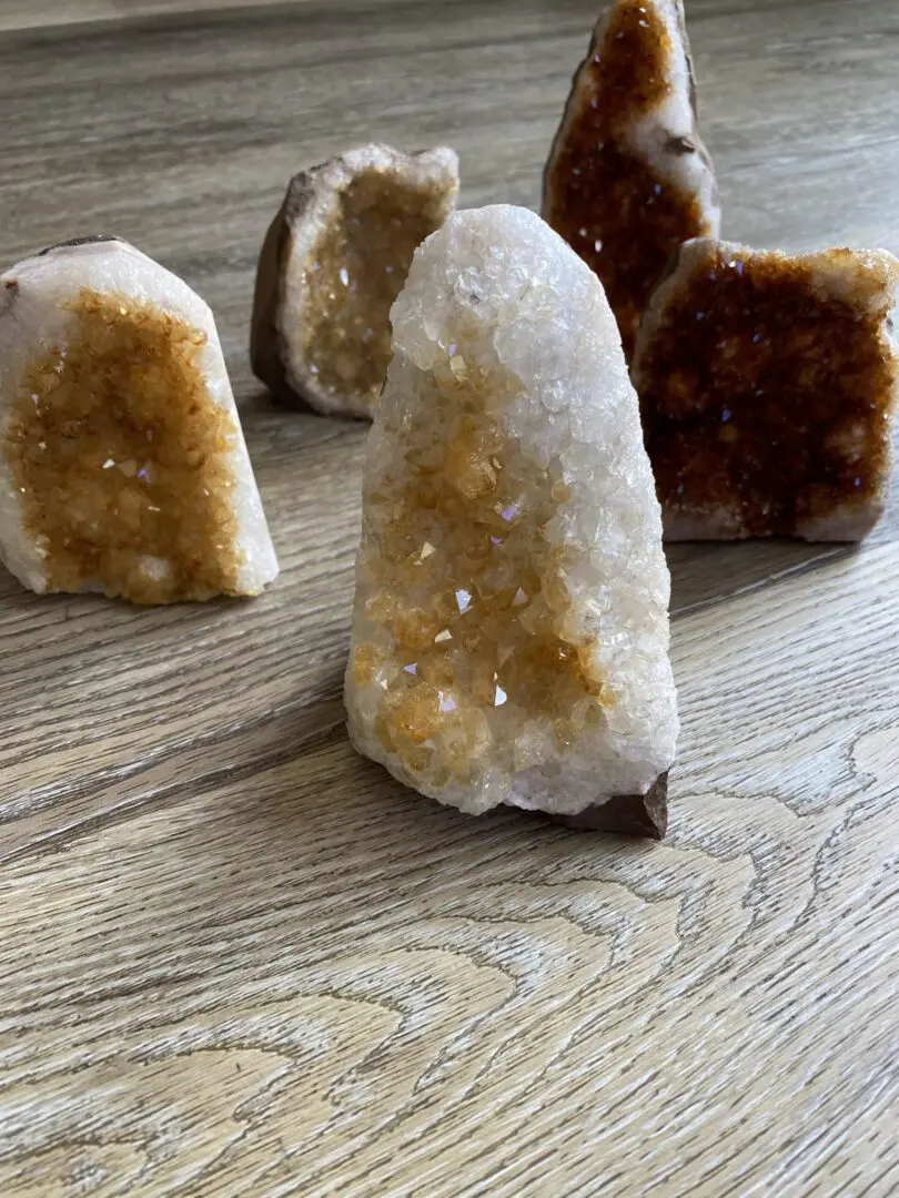 Four citrine crystal clusters on wood. Four citrine crystal clusters on wood.