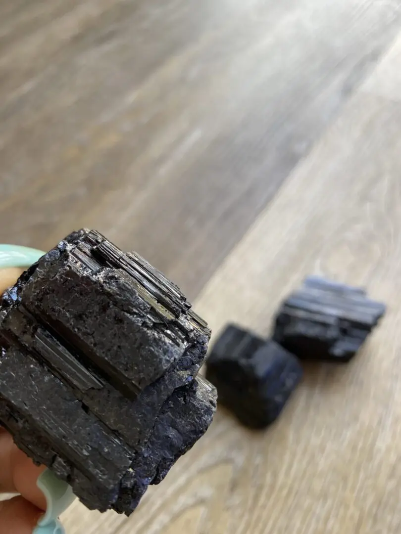 Black tourmaline crystal on wood table. Black tourmaline crystal on wood table.