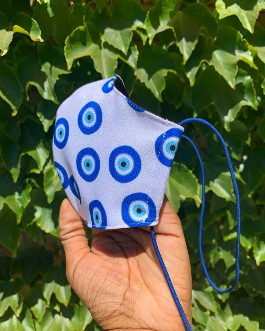 White face mask with blue evil eyes. White face mask with blue evil eyes.