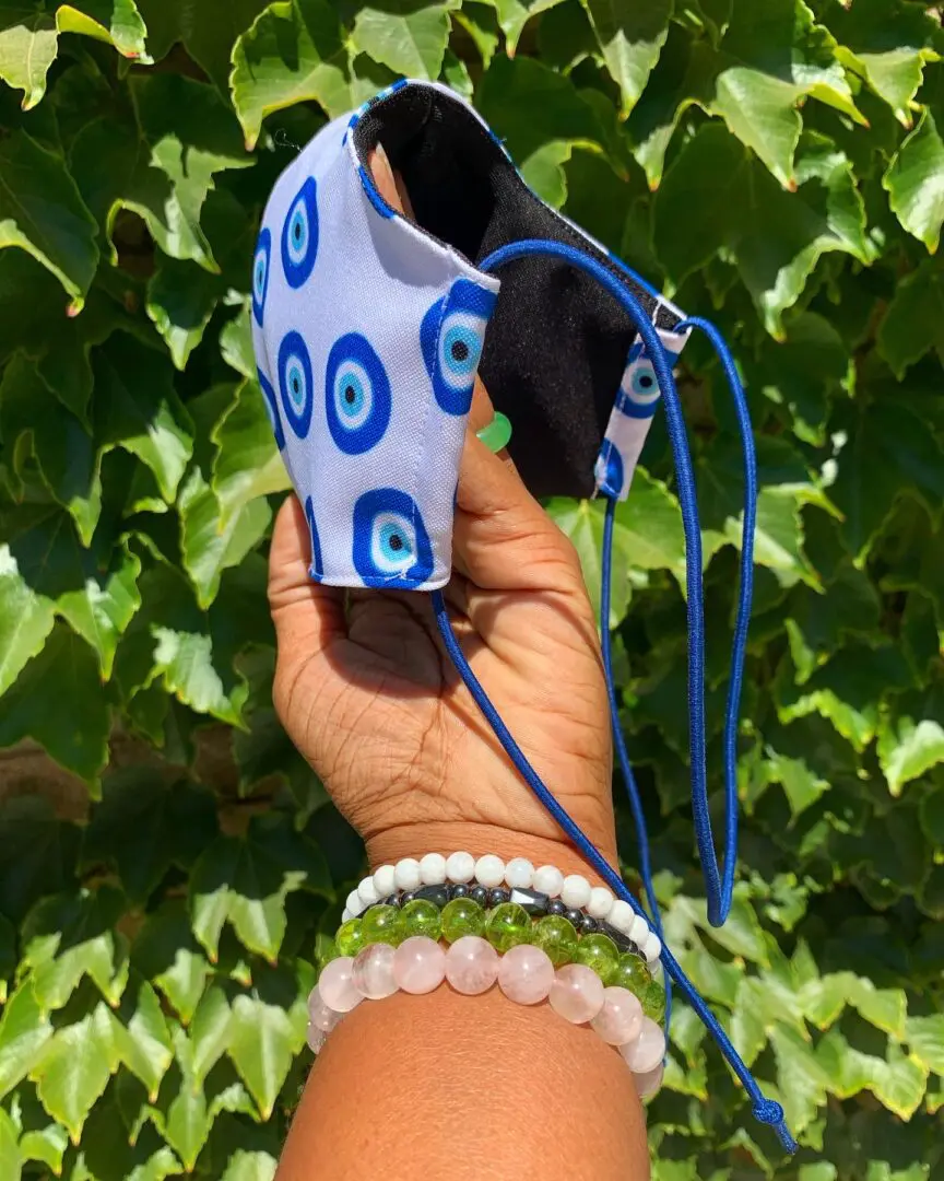 Evil eye patterned face mask with blue straps. Evil eye patterned face mask with blue straps.