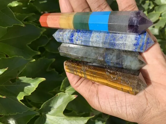 Five colorful crystal wands in hand. Five colorful crystal wands in hand.