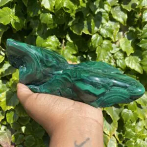 Green malachite crystal in hand.