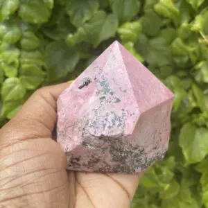 Pink Rhodonite crystal in hand.