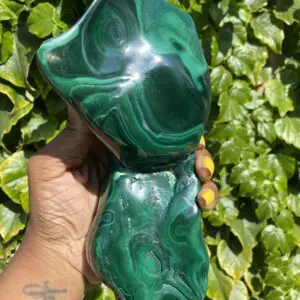 Green malachite stone held in hand.