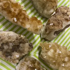 Six golden citrine crystals on green stripes.