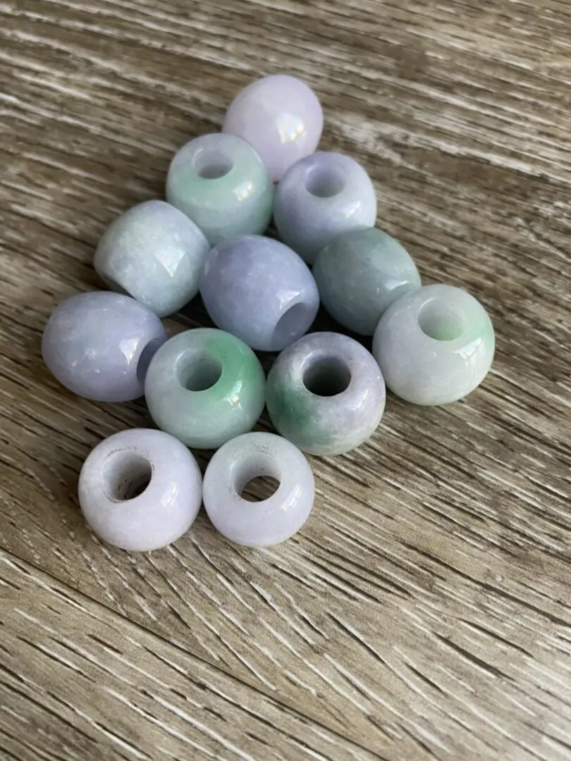 Green and white jade beads on wood. Green and white jade beads on wood.