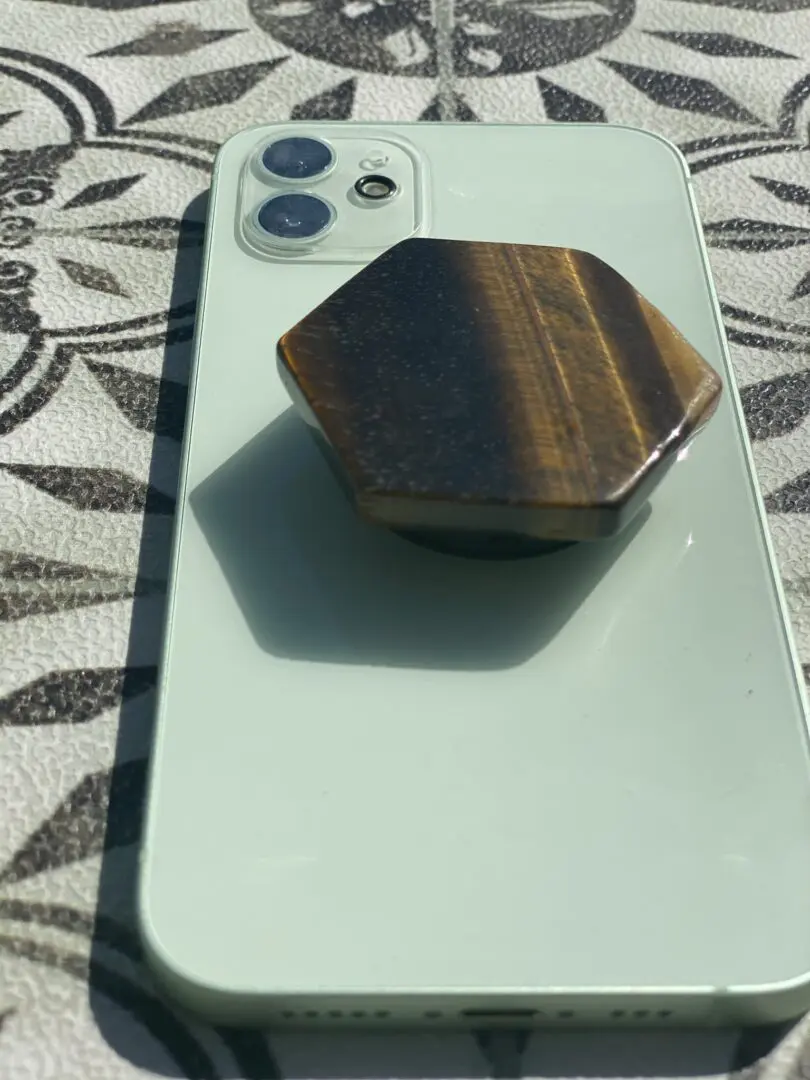 A phone is shown with a wooden holder. A phone is shown with a wooden holder.