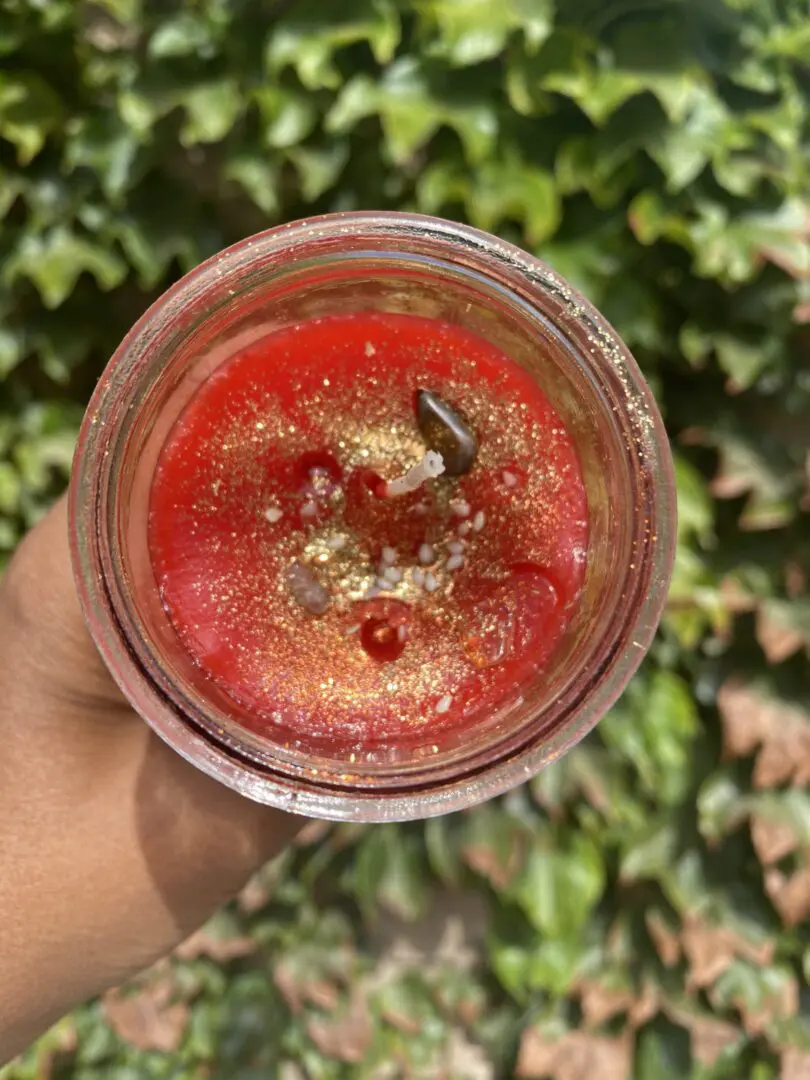 A person holding up a glass of juice. A person holding up a glass of juice.
