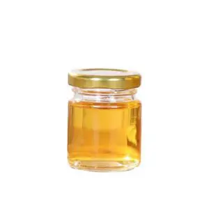 A jar of honey with gold lid on white background.