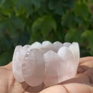 A person holding a bowl of rose quartz