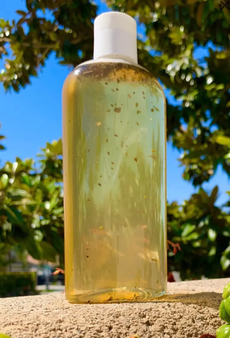 A bottle of liquid sitting on top of a table. A bottle of liquid sitting on top of a table.