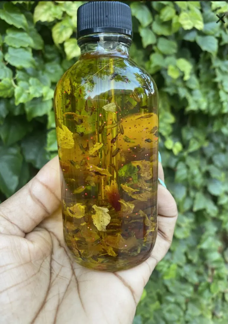 A person holding up a bottle of liquid. A person holding up a bottle of liquid.