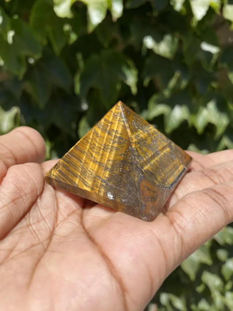 A person holding a small pyramid in their hand. A person holding a small pyramid in their hand.