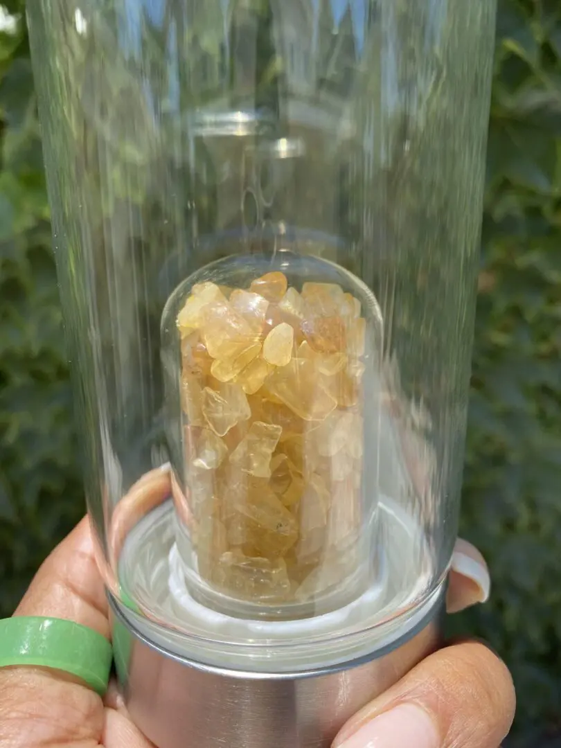 A person holding a glass container with some kind of substance inside it. A person holding a glass container with some kind of substance inside it.