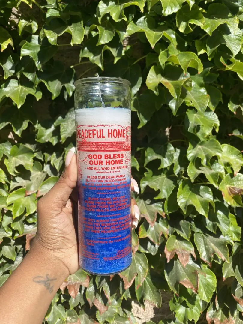 A person holding onto a candle that reads " stop blazes and pump." A person holding onto a candle that reads " stop blazes and pump."