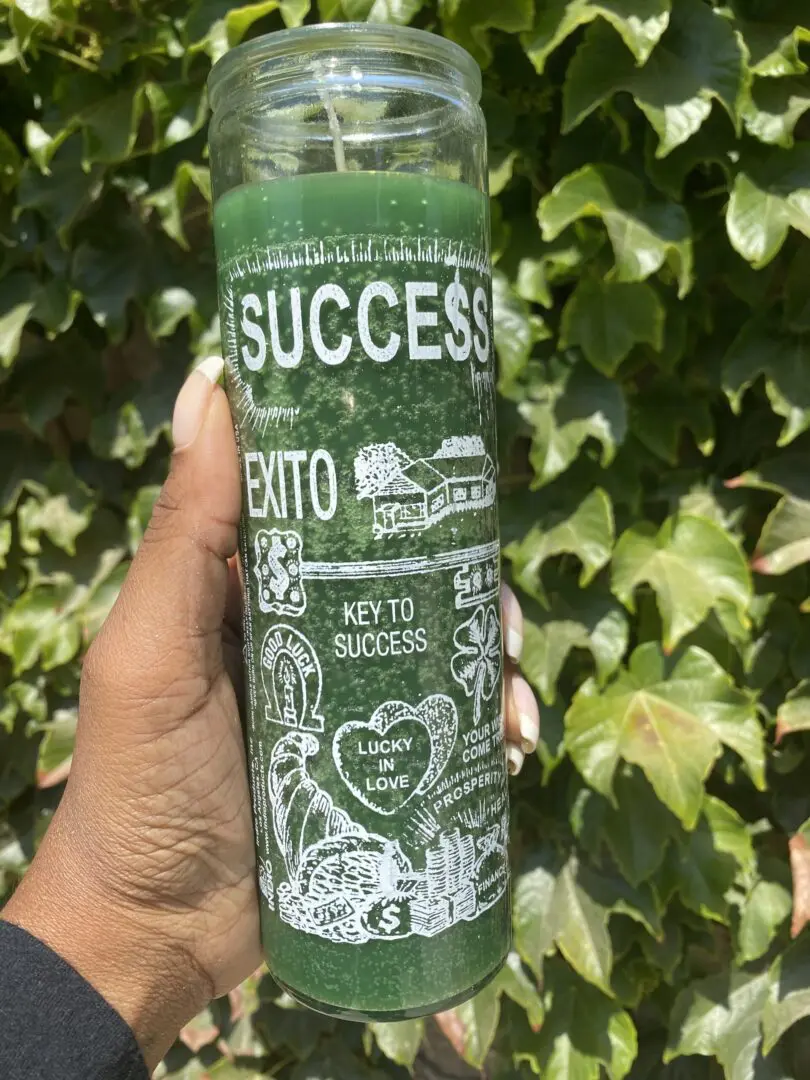 A person holding onto a candle with the word success written on it A person holding onto a candle with the word success written on it