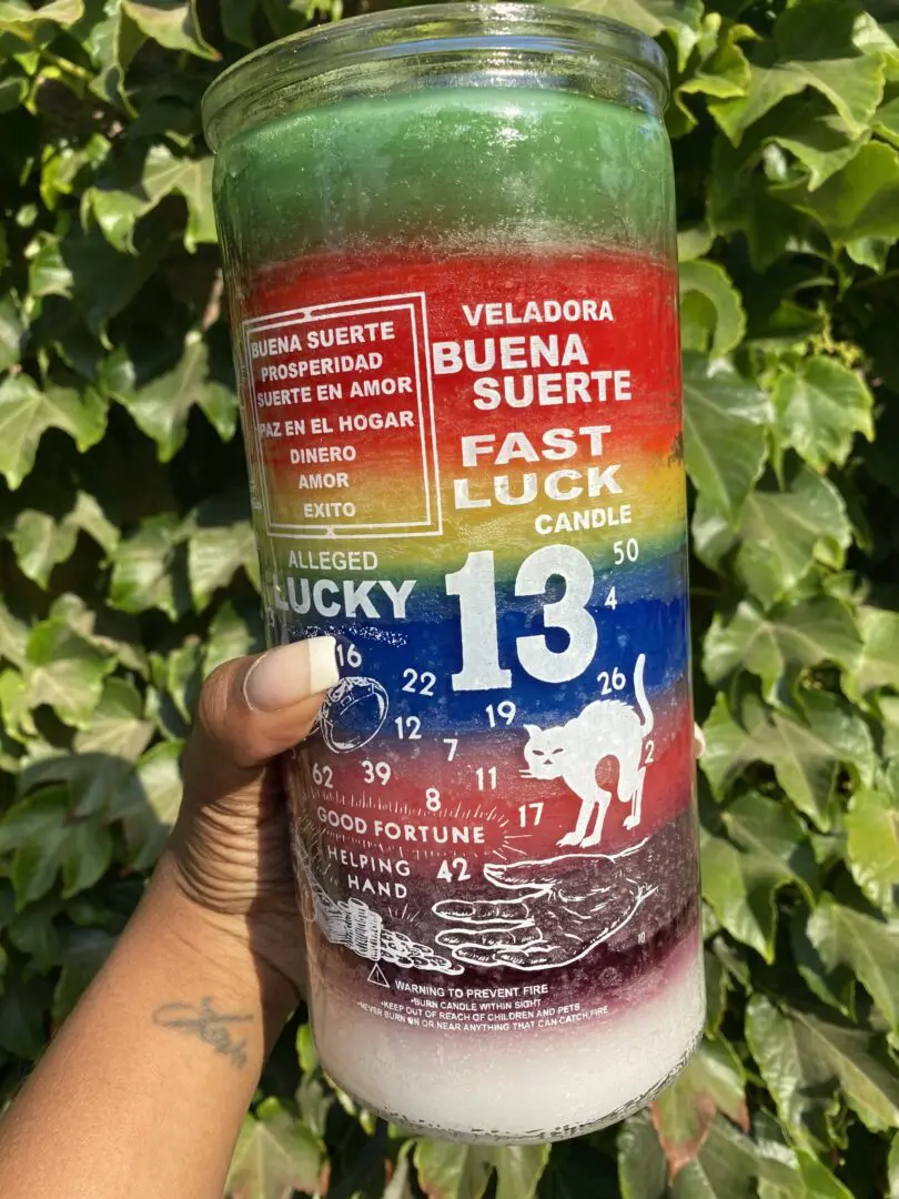 A person holding onto a candle that says lucky 1 3 A person holding onto a candle that says lucky 1 3