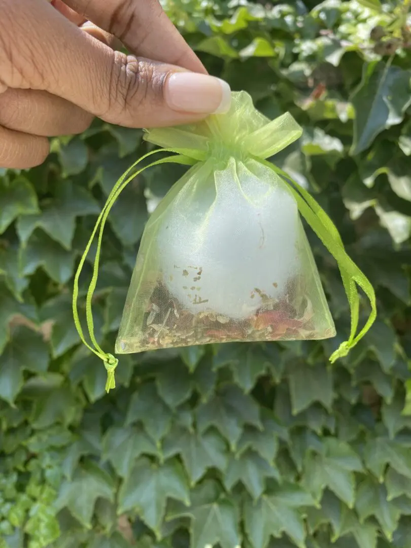 A person holding onto a small bag of tea A person holding onto a small bag of tea