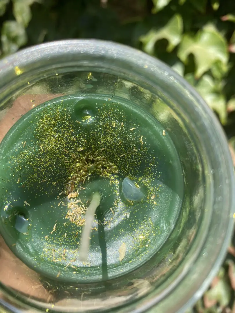 A glass of green liquid with some gold on it A glass of green liquid with some gold on it
