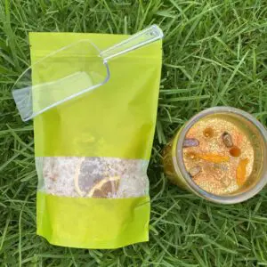 A cup and bag of food on the grass.