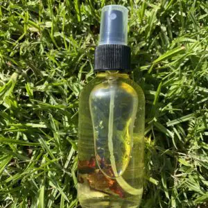 A bottle of oil sitting on top of grass.