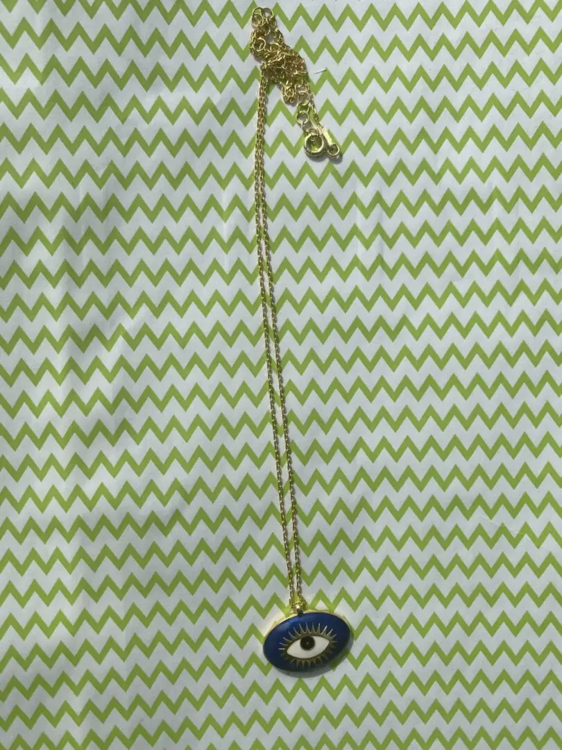 A necklace that is on top of a green and white background. A necklace that is on top of a green and white background.