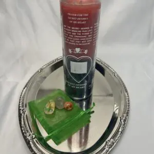 A candle and some green stuff on a silver tray