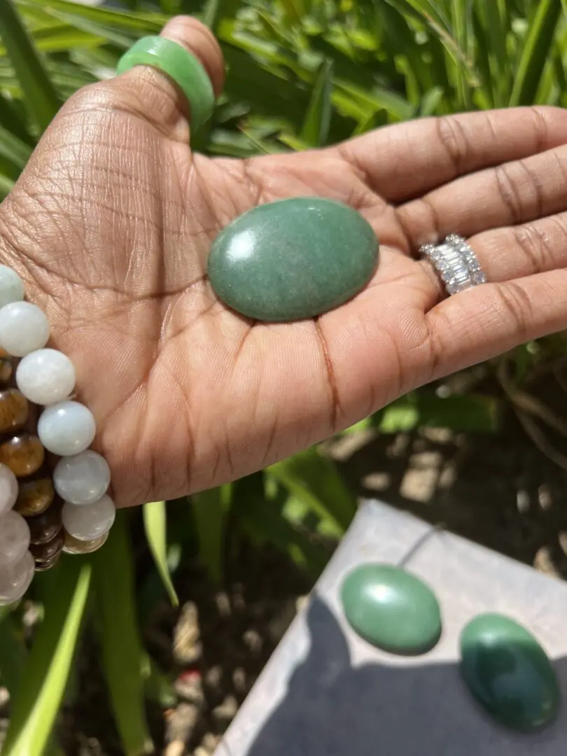 A person holding a green stone in their hand. A person holding a green stone in their hand.