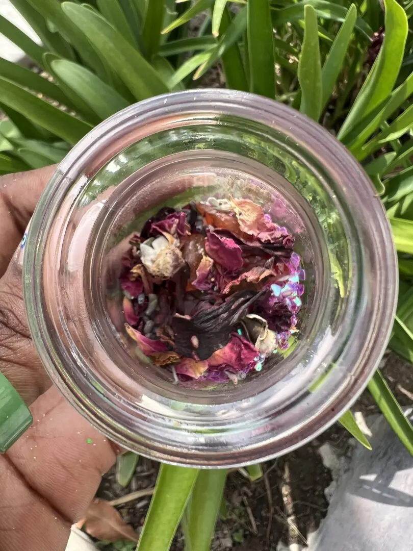 A person holding a glass with some food inside of it A person holding a glass with some food inside of it