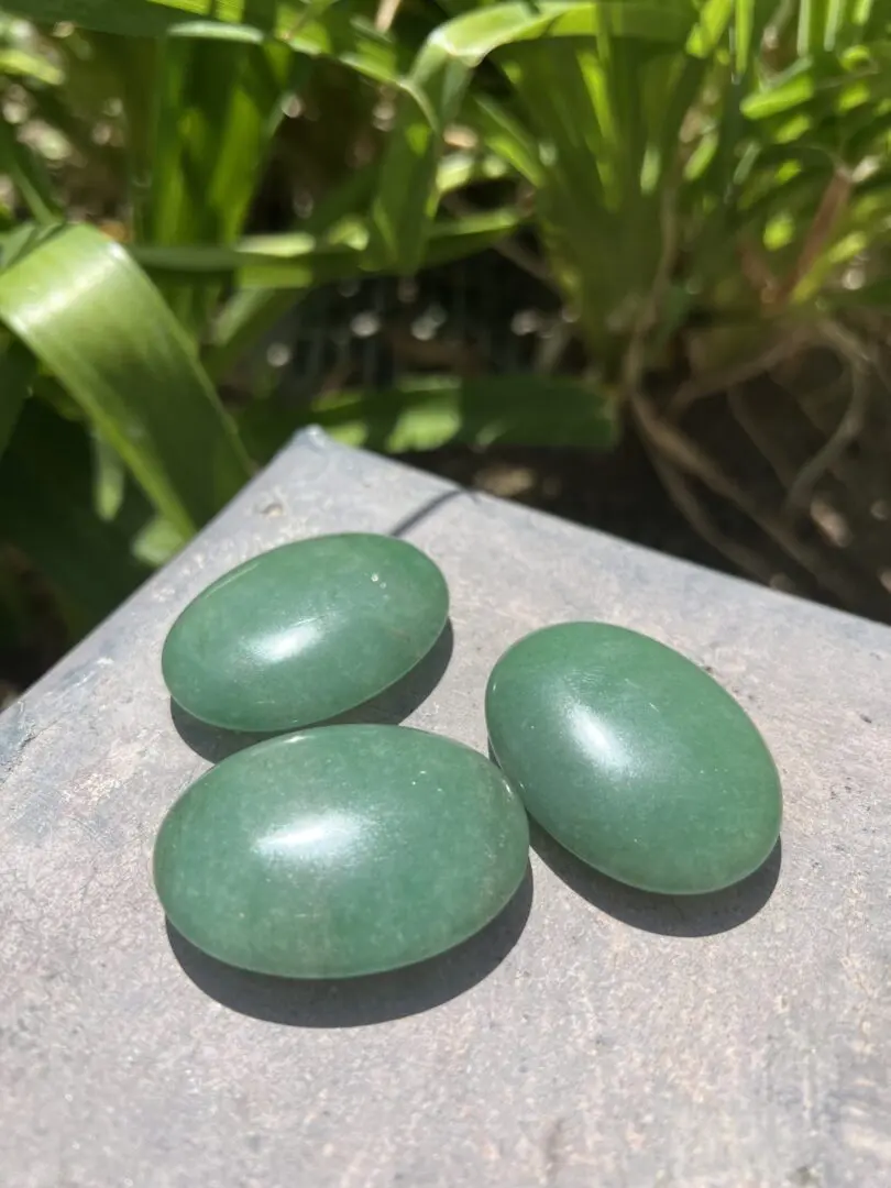 Three green stones sitting on top of a table. Three green stones sitting on top of a table.