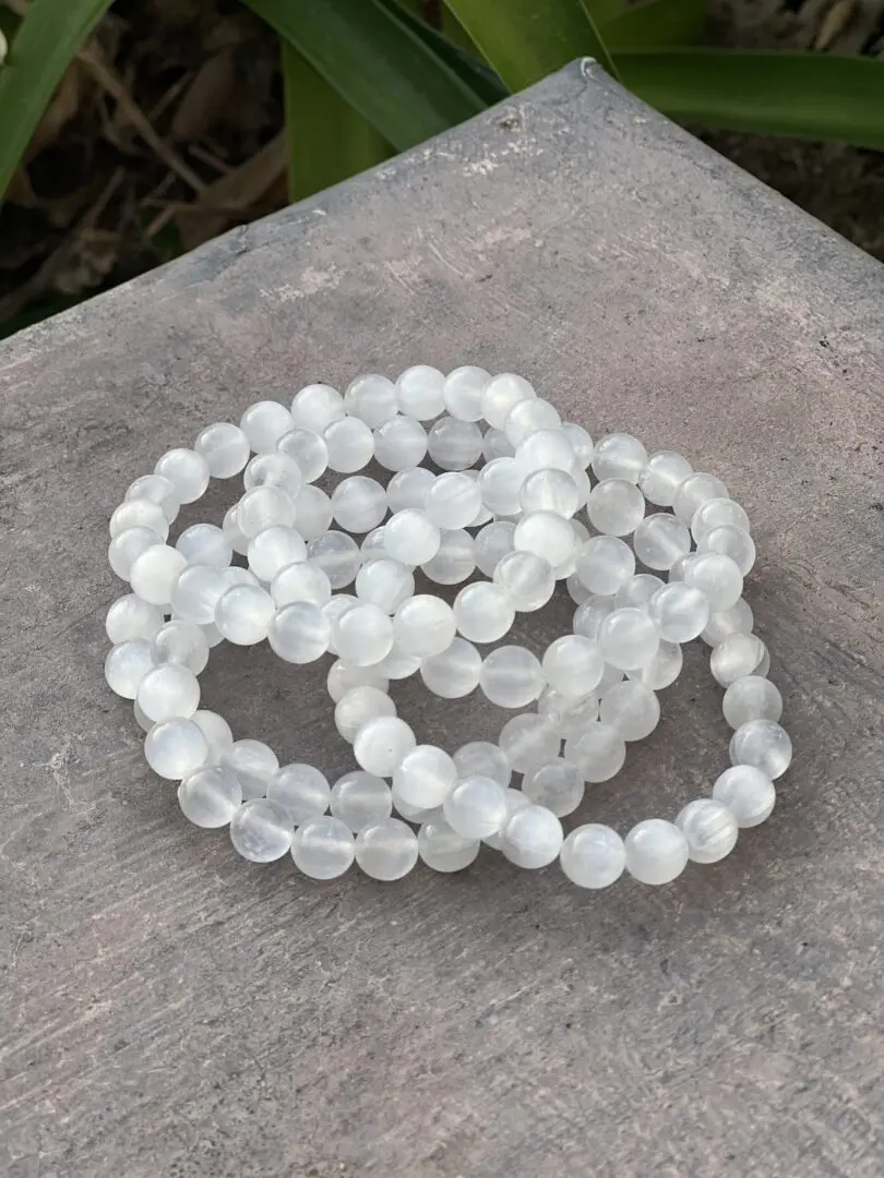 A stack of white beads sitting on top of a table. A stack of white beads sitting on top of a table.