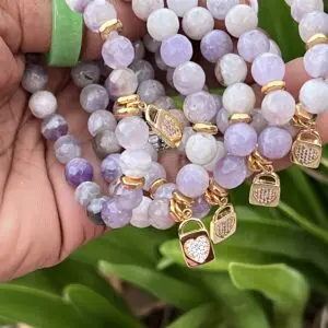 A hand holding onto some bracelets with charms