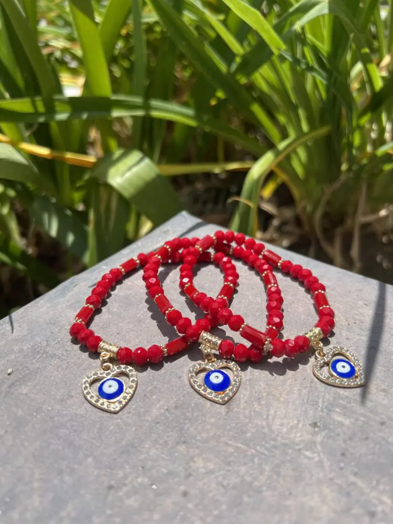 A close up of three bracelets on top of a wooden table. A close up of three bracelets on top of a wooden table.