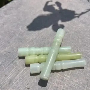 A group of four green pipes sitting on top of a wooden table.