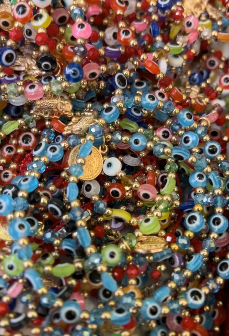 A pile of colorful beads with evil eye charms. A pile of colorful beads with evil eye charms.