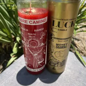 A candle and a can of luck are sitting on the ground.